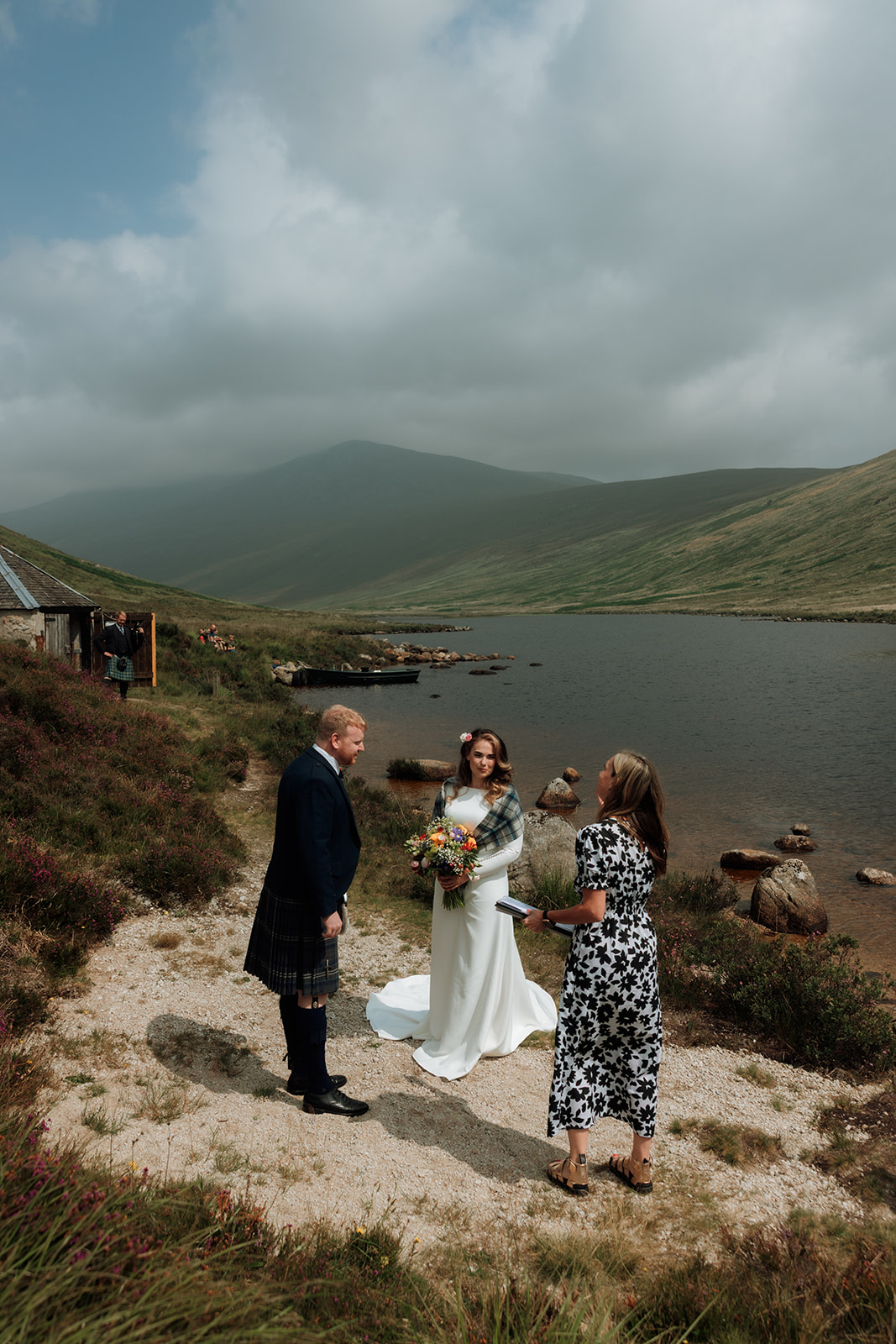 Bride and groom exchanging vows outdoors by Loch Iorsa, Isle of Arran.