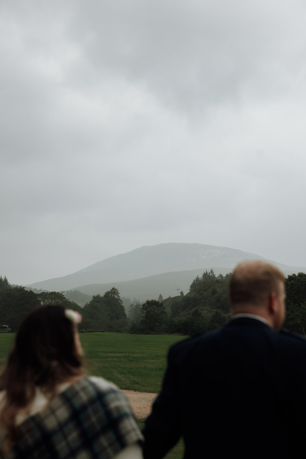 Bride and groom standing with misty hills in background during Isle of Arran elopement.