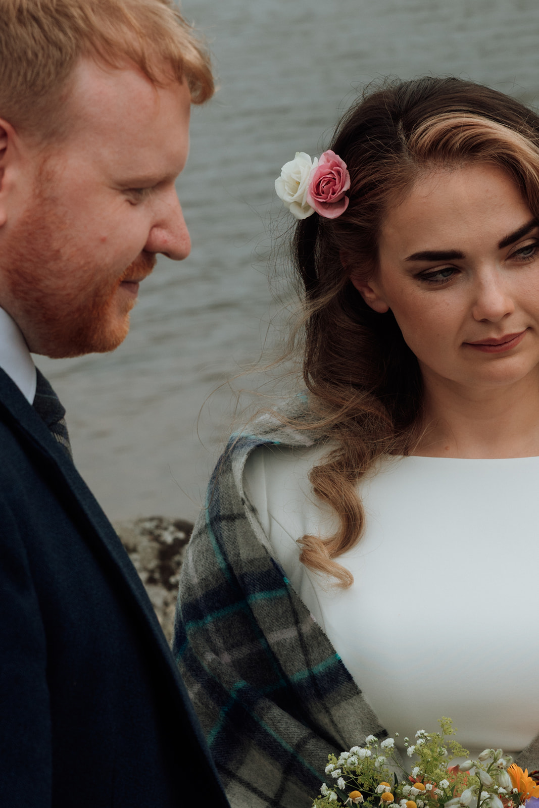 Bride in white dress and tartan shawl standing beside her groom during Isle of Arran elopement.