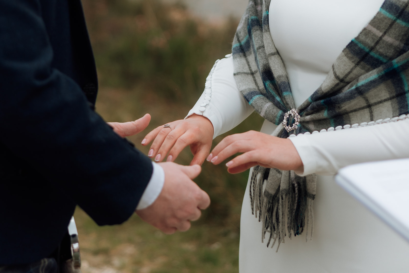 Groom placing wedding ring on bride’s hand during Isle of Arran elopement ceremony.