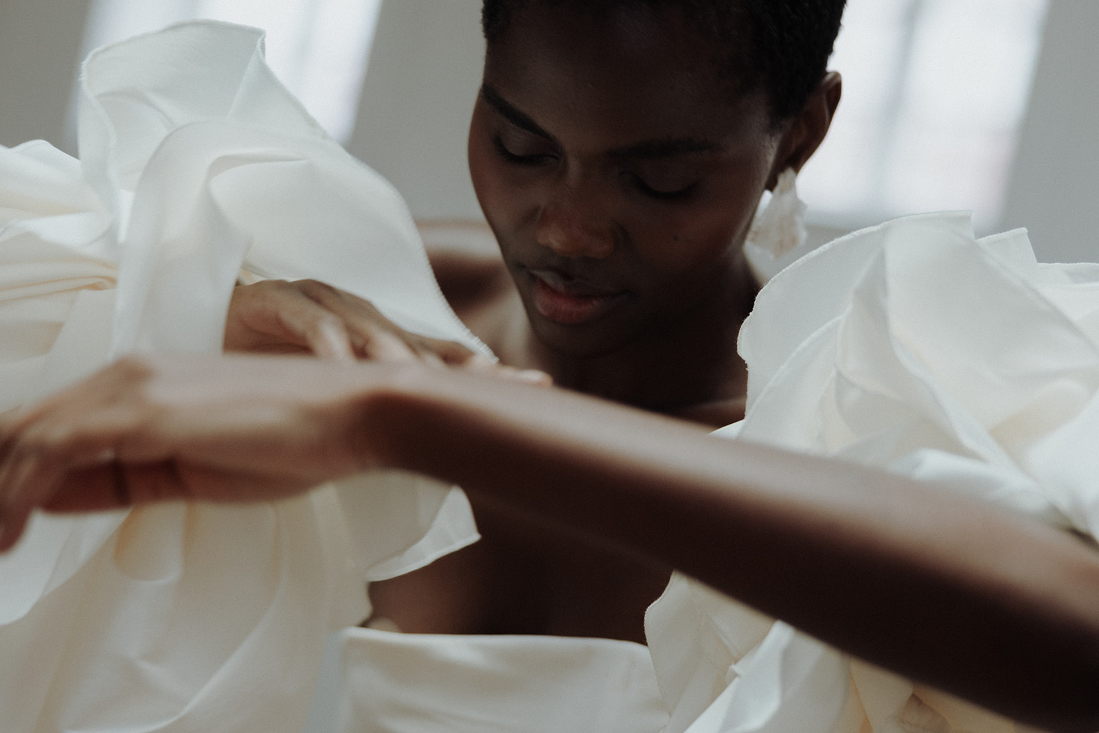 Bride in strapless couture gown with ruffled detail, close-up editorial bridal portrait.