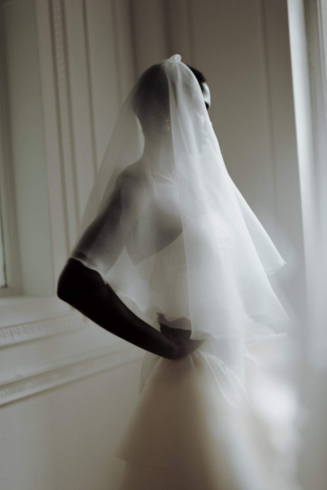Bride in Darla Haute Couture gown with veil, blurred editorial motion portrait.