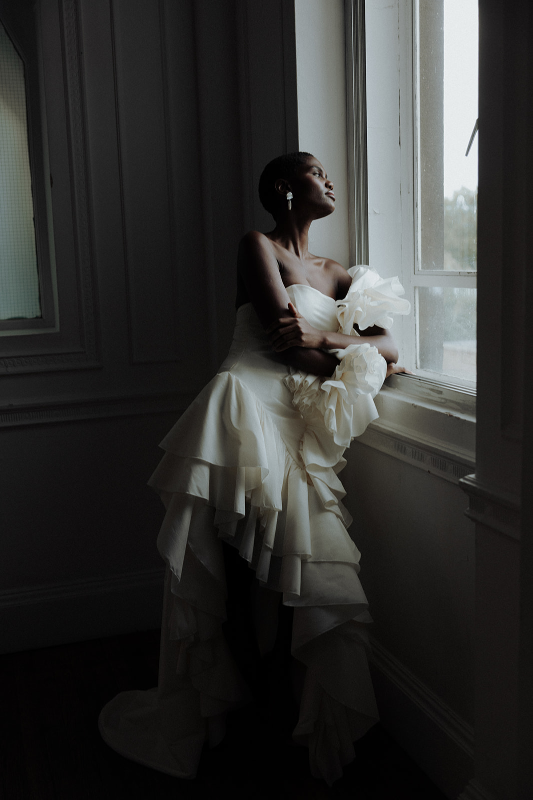 Bride in couture gown with oversized ruffled sleeve, modern bridal editorial.