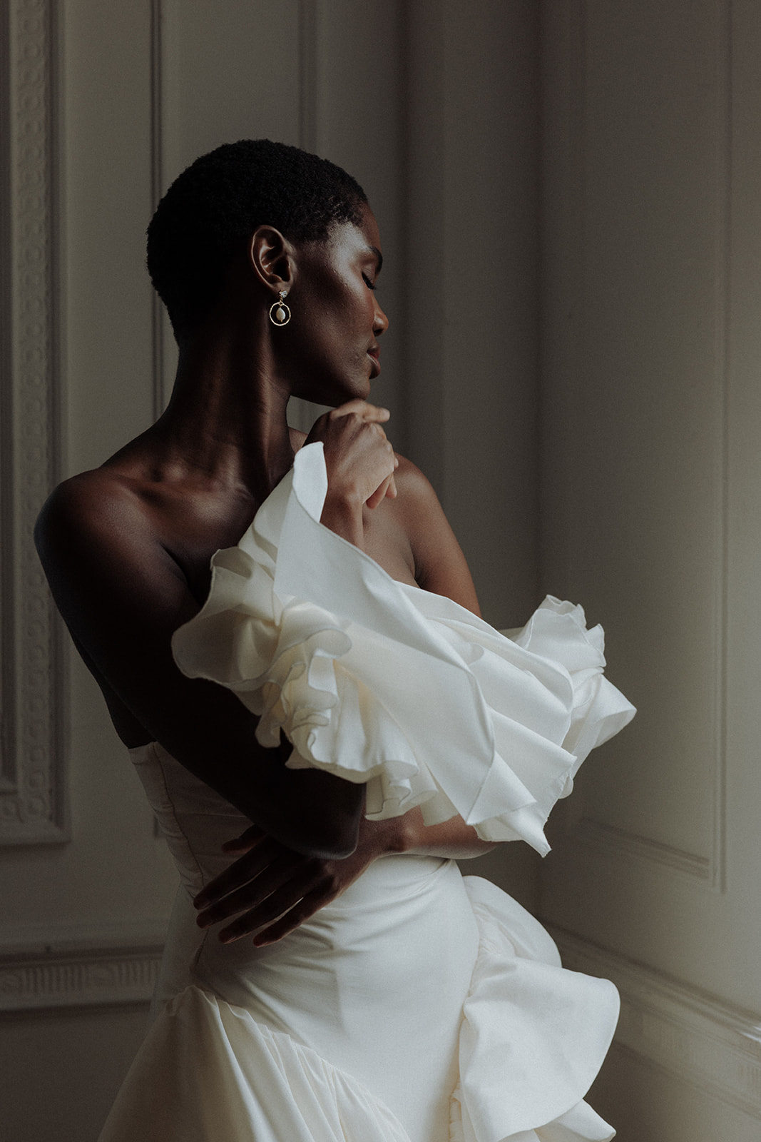 Luminous statement bridal earrings styled with couture gown, editorial close-up.
