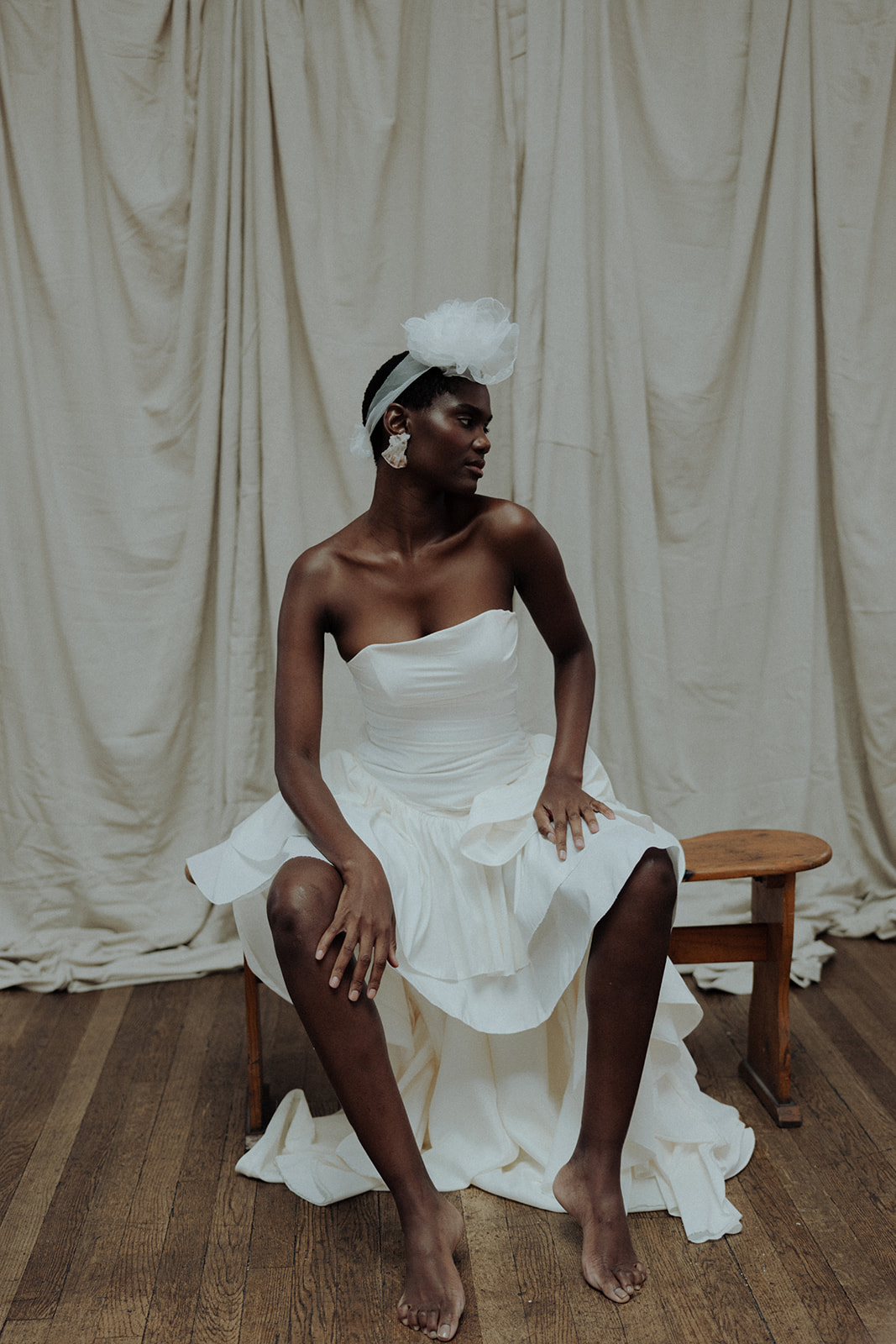 An editorial bridal portrait featuring couture gown and dramatic headpiece, photographed with elegance and restraint.