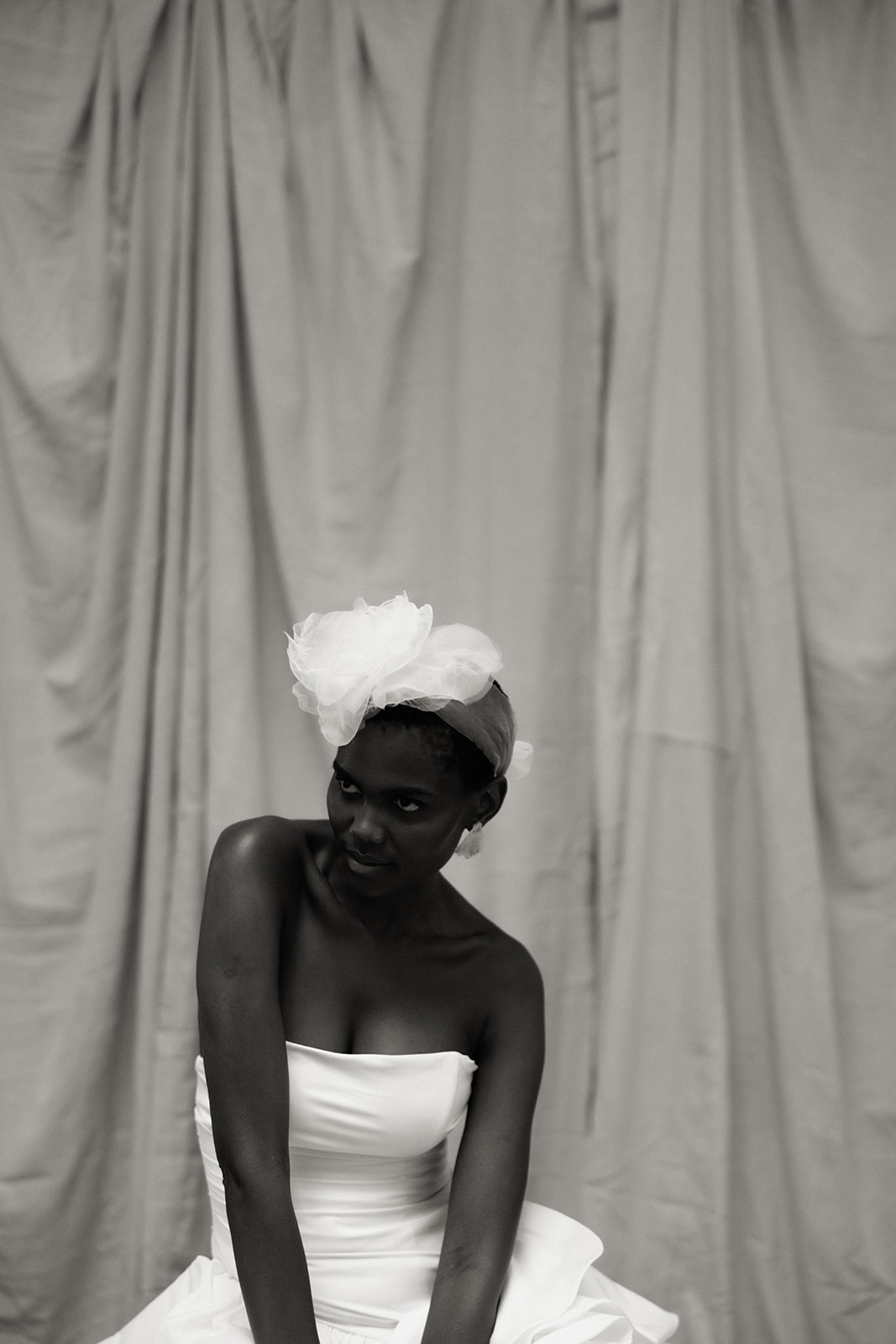 Black and white bridal editorial portrait with couture gown and sculptural headpiece.