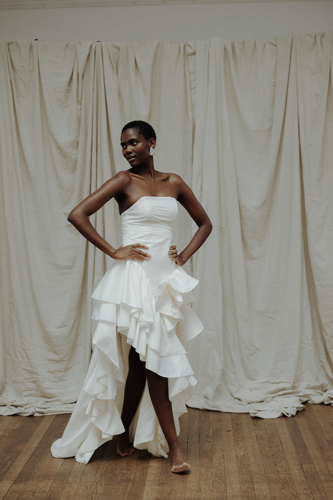 Bride in strapless Darla Haute Couture gown with high-low hem, editorial bridal fashion photograph.