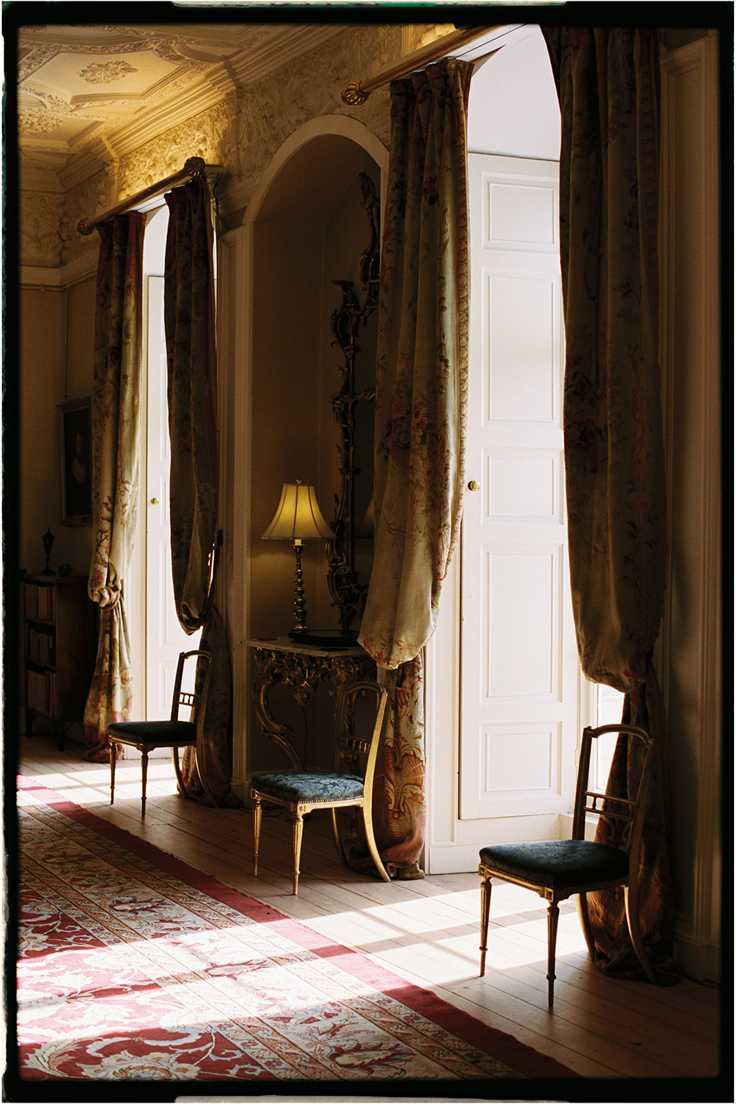 Light streaming through tall windows into the grand hall at Winton Castle, Edinburgh.